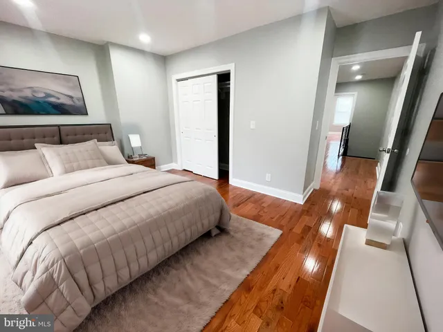 a bedroom with a large bed and a painting on the wall