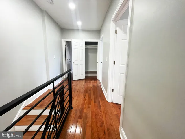 a view of a hallway with wooden floor and staircase