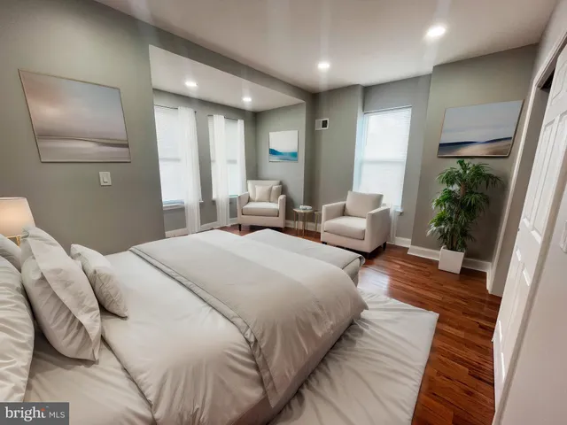 a spacious bedroom with a bed and wooden floor