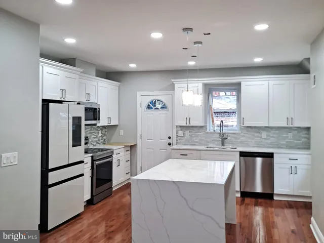 a kitchen with kitchen island a sink stainless steel appliances and window