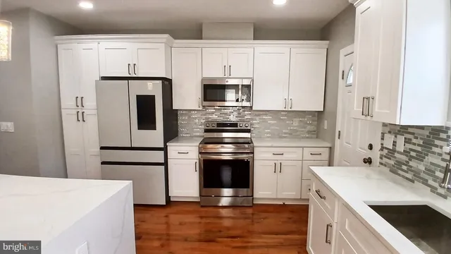 a kitchen with a refrigerator stove and white cabinets
