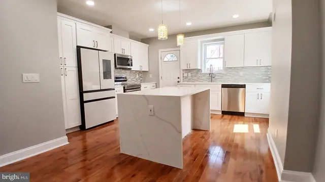 a kitchen with white cabinets and appliances