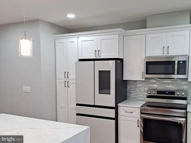 a kitchen with cabinets and stainless steel appliances