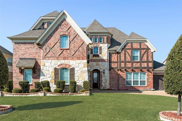 front view of a brick house with a yard