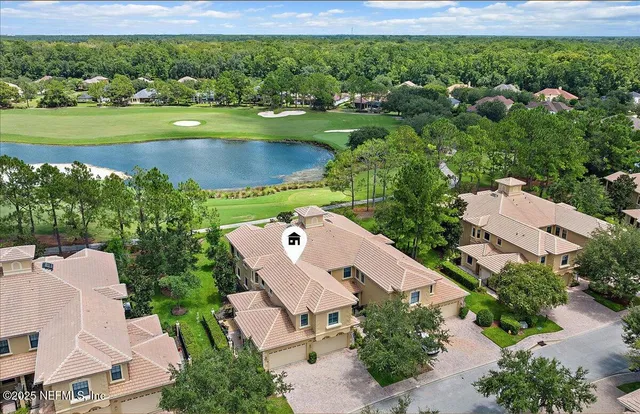 an aerial view of a house with a garden and lake view