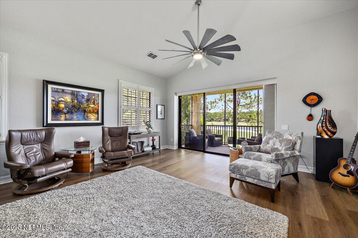 174 Laterra Links Circle, Unit 201 St. Augustine, FL 32092 - Photo 15 of 41 a living room with furniture floor to ceiling window and a flat screen tv