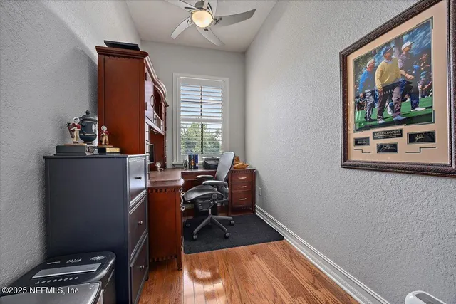 a view of a workspace with furniture and a window