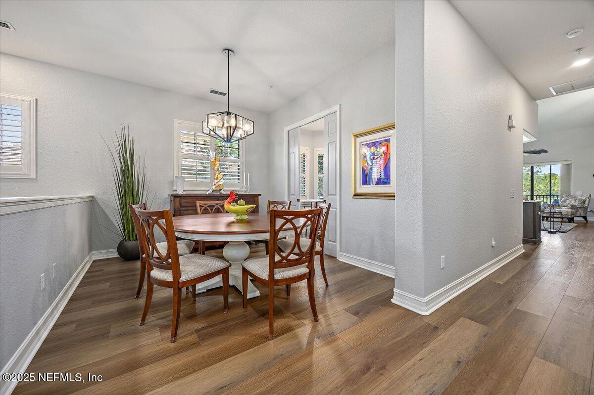 174 Laterra Links Circle, Unit 201 St. Augustine, FL 32092 - Photo 8 of 41 a dining room with furniture a chandelier and wooden floor