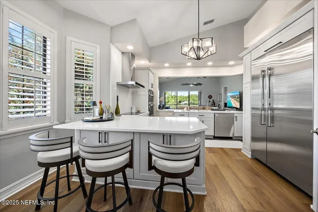 a kitchen with a center island appliances and cabinets