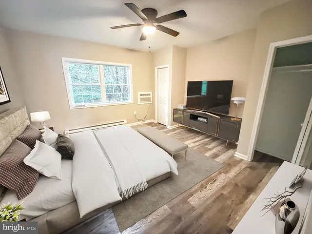 a bedroom with a bed and a flat tv screen on dresser