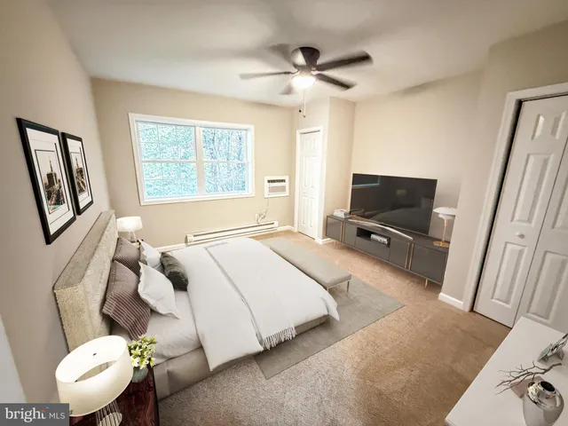 a bedroom with a bed a couch and a flat tv screen