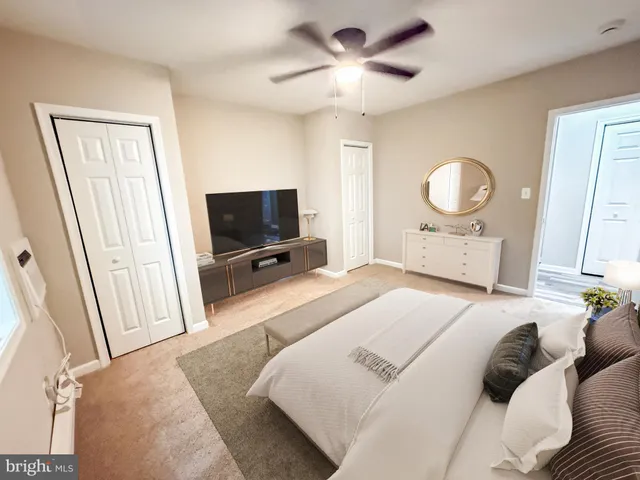 a bedroom with a bed a window and a flat screen tv