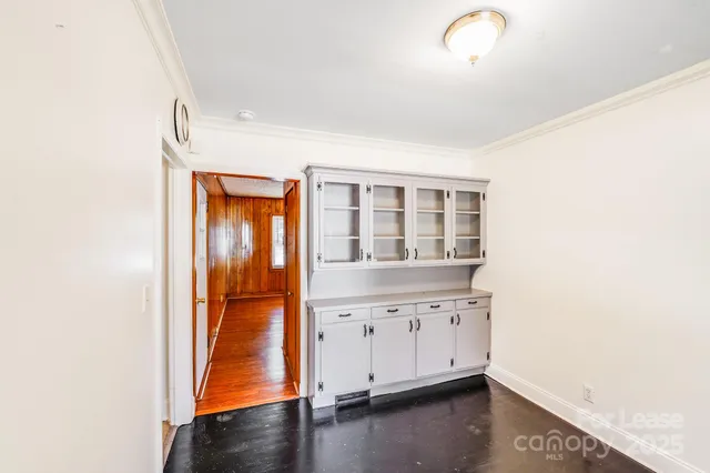 an empty room with wooden floor and cabinet