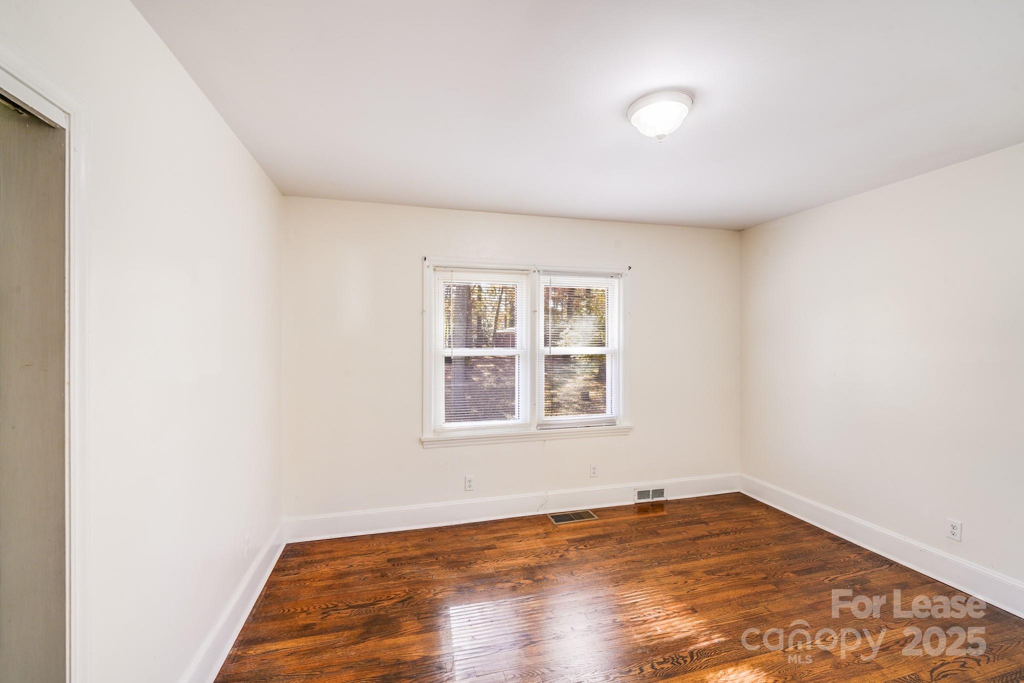 5311 Princess Street Charlotte, NC 28269 - Photo 15 of 24 an empty room with wooden floor and windows