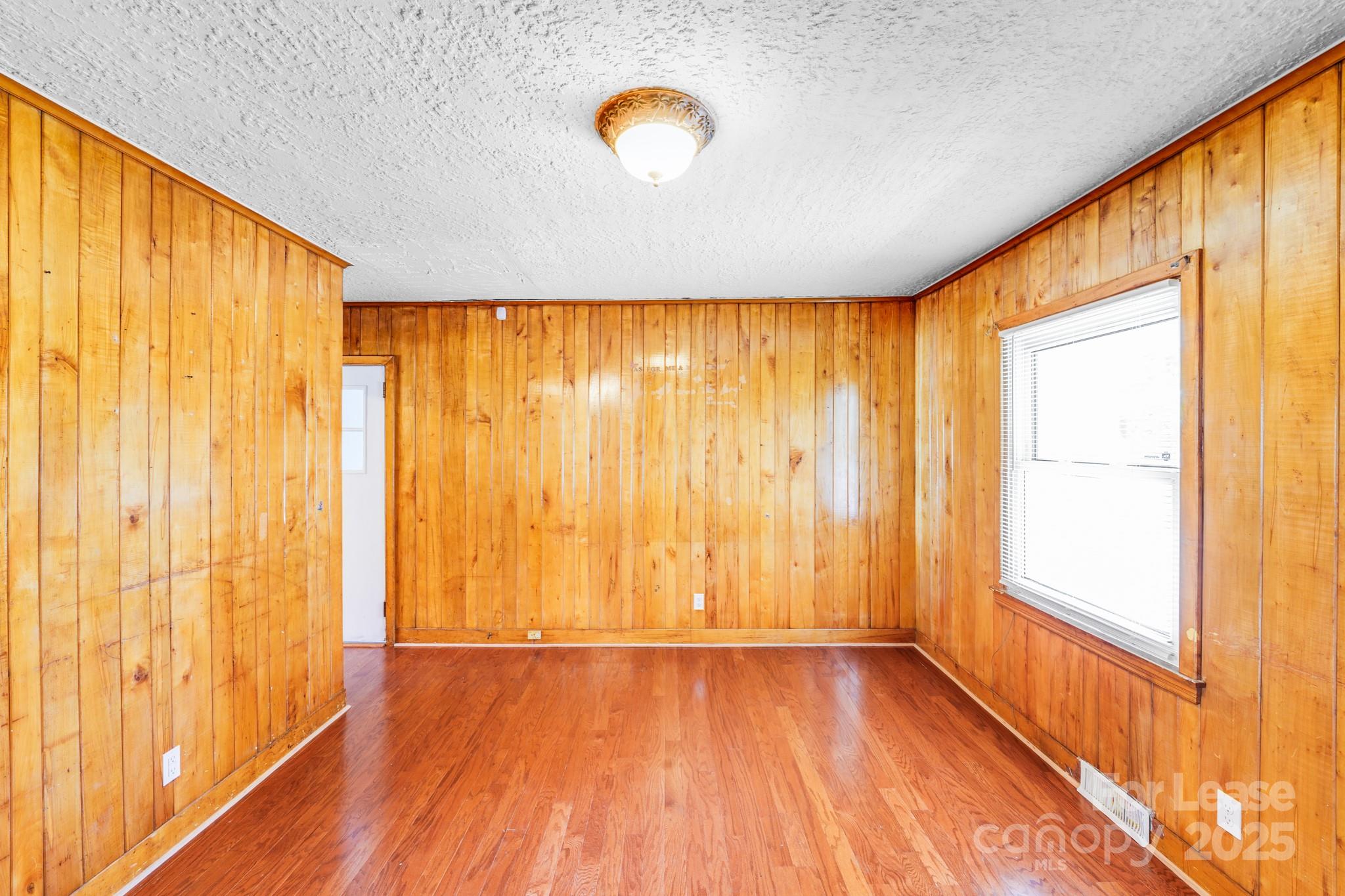 5311 Princess Street Charlotte, NC 28269 - Photo 8 of 24 a view of an empty room with wooden floor and a window