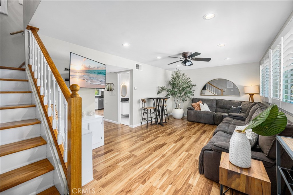 4237 Larwin Avenue Cypress, CA 90630 - Photo 7 of 48 a view of a livingroom with furniture wooden floor windows and a ceiling fan