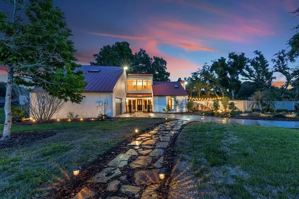 a front view of a house with a yard and trees