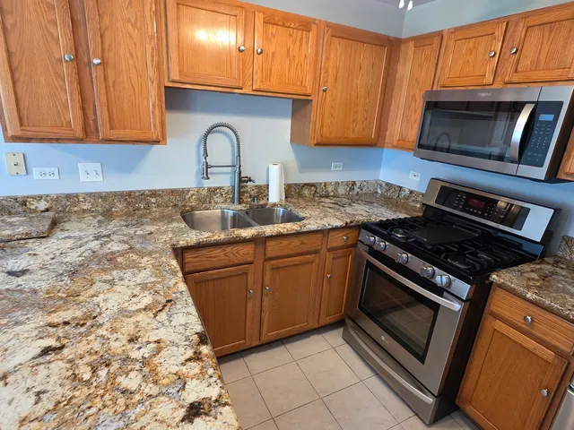 a kitchen with granite countertop cabinets stainless steel appliances and a sink