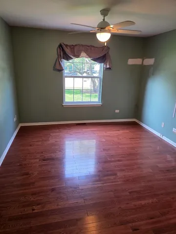 a view of room with wooden floor and fan