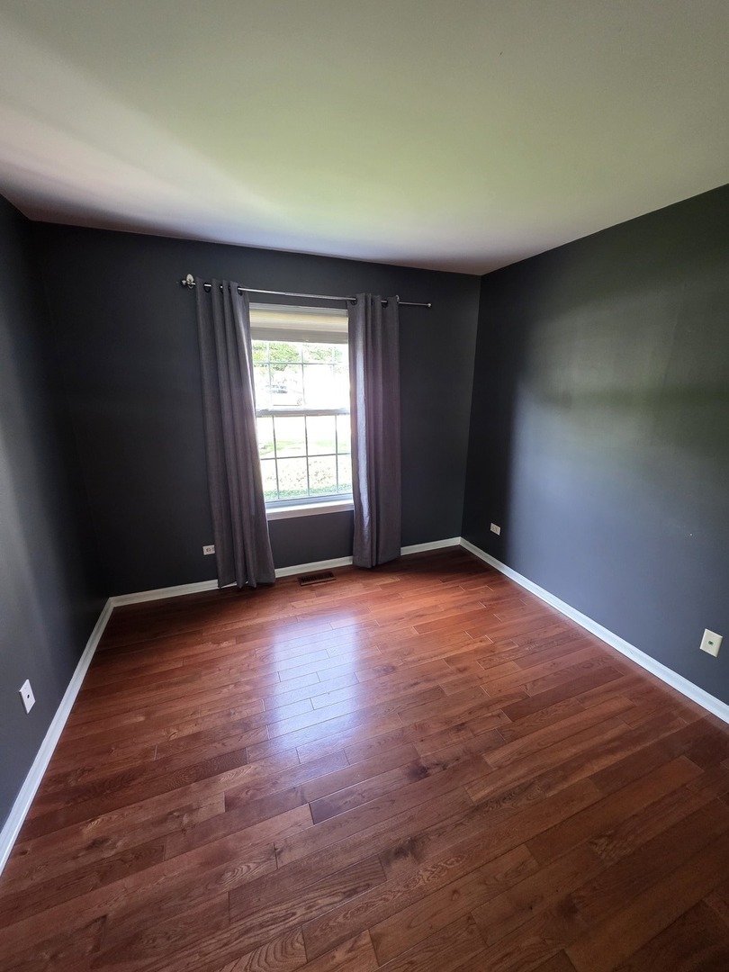 408 Woodview Circle, Unit B Elgin, IL 60120 - Photo 19 of 26 an empty room with wooden floor and windows