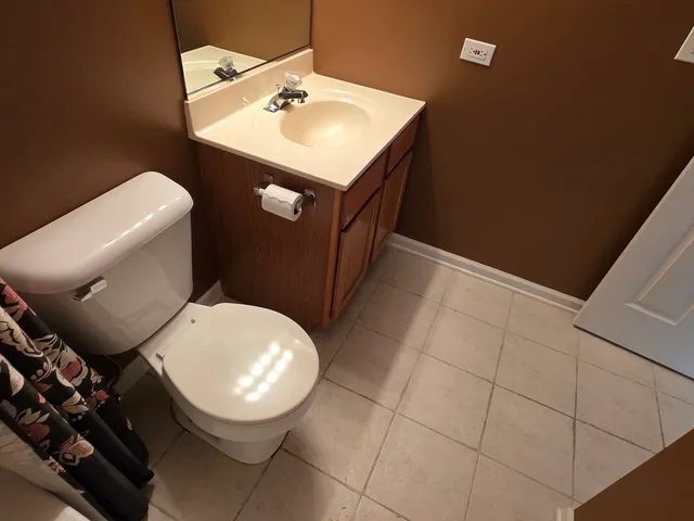 a bathroom with a toilet a sink and mirror