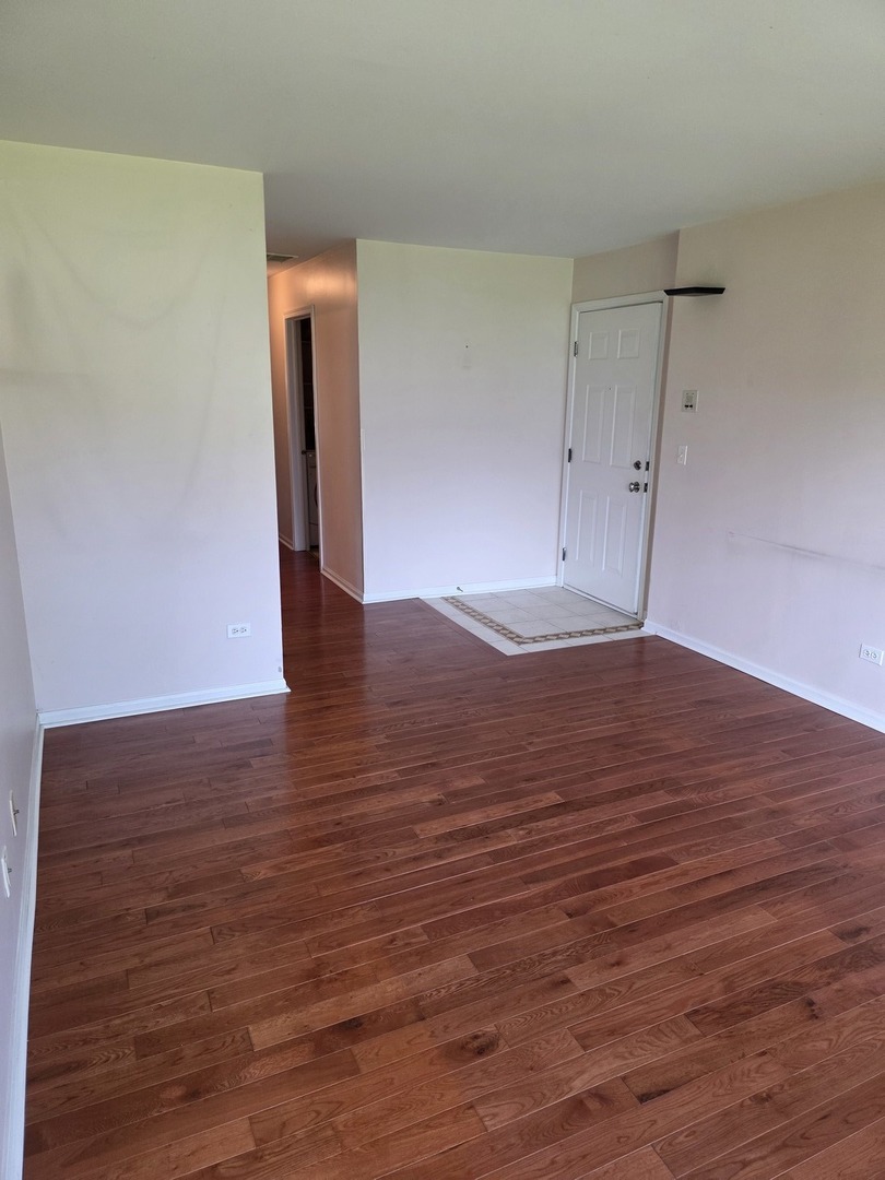 408 Woodview Circle, Unit B Elgin, IL 60120 - Photo 4 of 26 a view of an empty room with wooden floor
