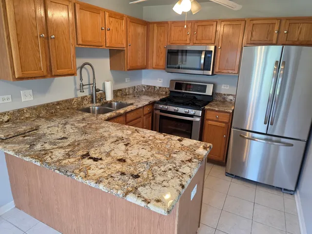 a kitchen with stainless steel appliances granite countertop a refrigerator stove top oven a sink and dishwasher