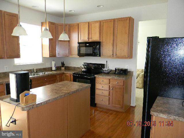 1702 Conrads Ferry Drive Point of Rocks, MD 21777 - Photo 8 of 29 a kitchen with stainless steel appliances granite countertop a refrigerator a sink dishwasher a stove top oven a dining table and chairs with wooden floor