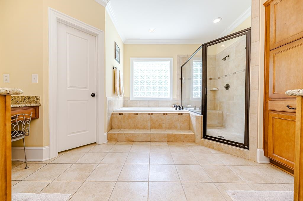 225 Henrys Ridge Road Pittsboro, NC 27312 - Photo 31 of 67 Primary bath includes a luxurious jetted tub alongside a huge shower with dual shower heads. Custom cabinetry. Separate walk-in closets.