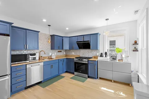 a kitchen with stainless steel appliances granite countertop a refrigerator sink and wooden cabinets