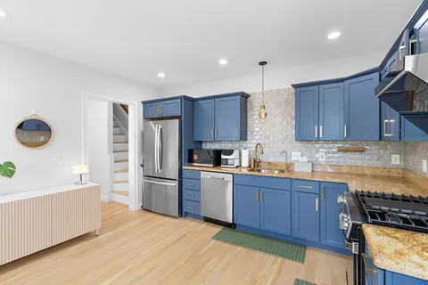a kitchen with stainless steel appliances wooden cabinets and a stove top oven