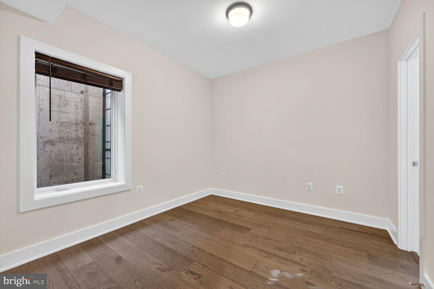 1412 Chapin Street Northwest, Unit 2 Washington, DC 20009 - Photo 14 of 15 an empty room with wooden floor and windows