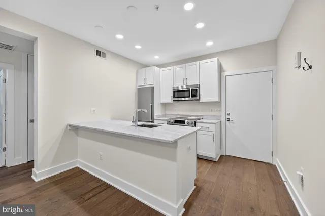 a kitchen with white cabinets and white appliances