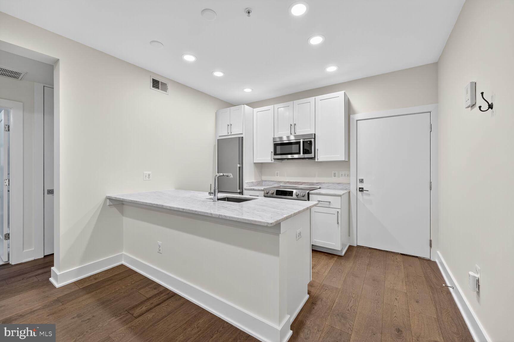 1412 Chapin Street Northwest, Unit 2 Washington, DC 20009 - Photo 4 of 15 a kitchen with white cabinets and white appliances