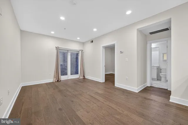 a view of empty room with wooden floor