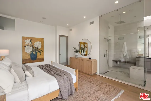 a bedroom with a large bed and a mirror