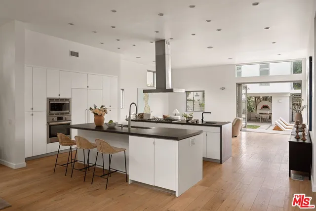 a kitchen with stainless steel appliances granite countertop a stove and chairs