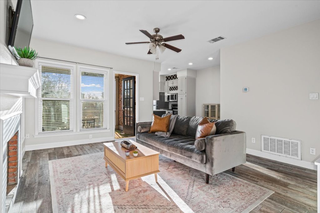 Living area featuring wood-style tile flooring, and recessed lighting with plentiful of natural light.