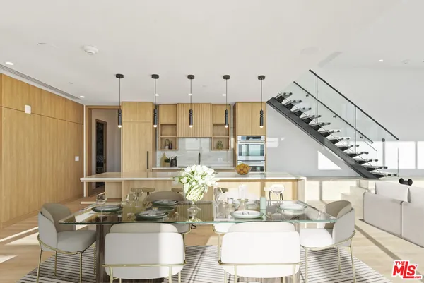 a room with lots of white furniture and a large window