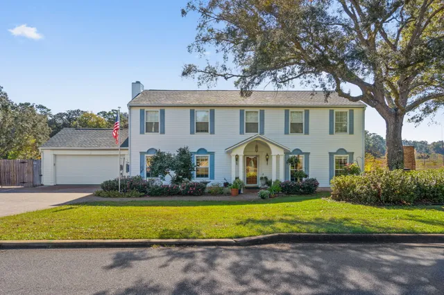 a front view of a house with a yard and trees