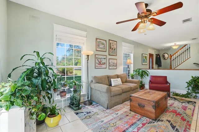 a living room with furniture a flat screen tv and a large window