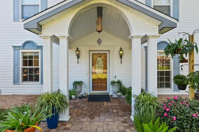 an aerial view of residential house with outdoor space and trees all around