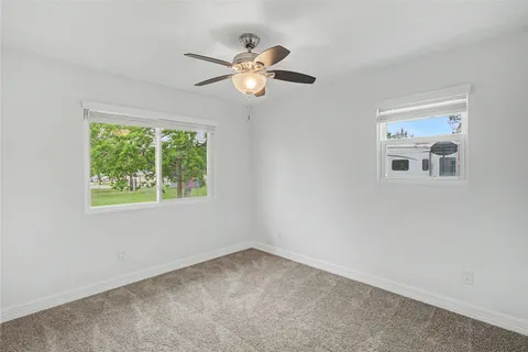 a view of wooden floor and a chandelier fan in a room
