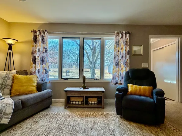a living room with furniture ceiling fan and a window