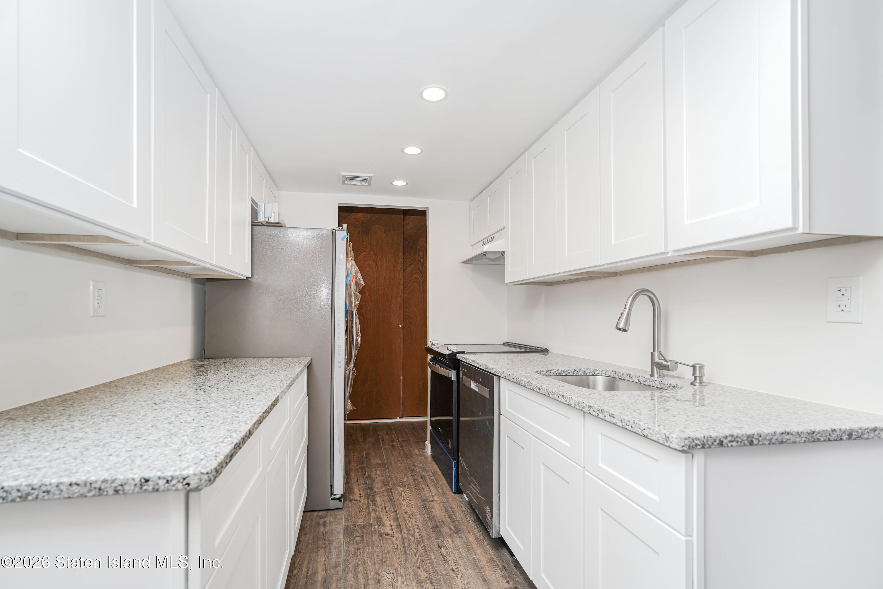 5 Windham Loop, Unit 6E Staten Island, NY 10314 - Photo 13 of 25 a kitchen with stainless steel appliances granite countertop a sink stove and cabinets