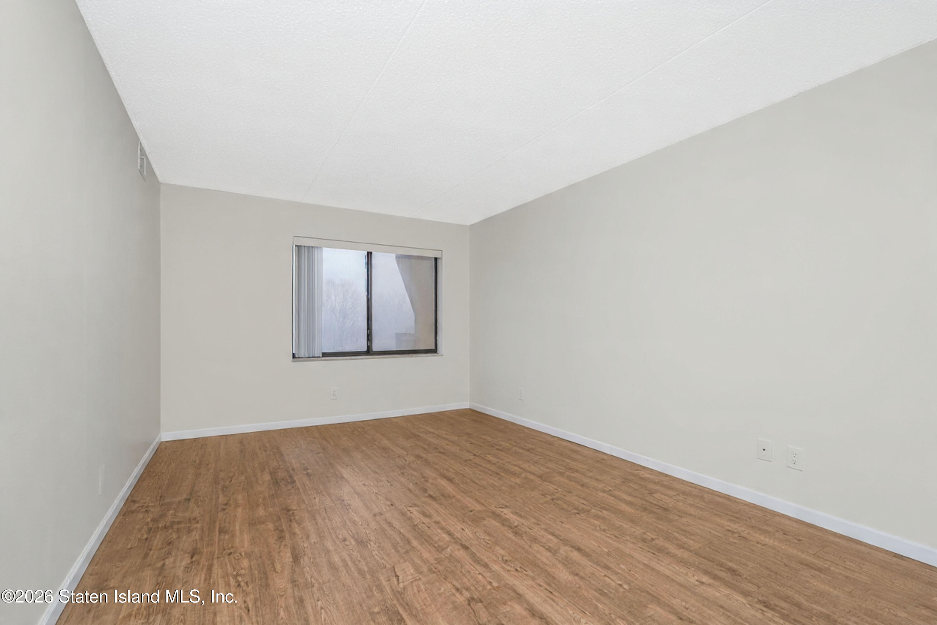 5 Windham Loop, Unit 6E Staten Island, NY 10314 - Photo 19 of 25 a view of empty room with wooden floor and fan