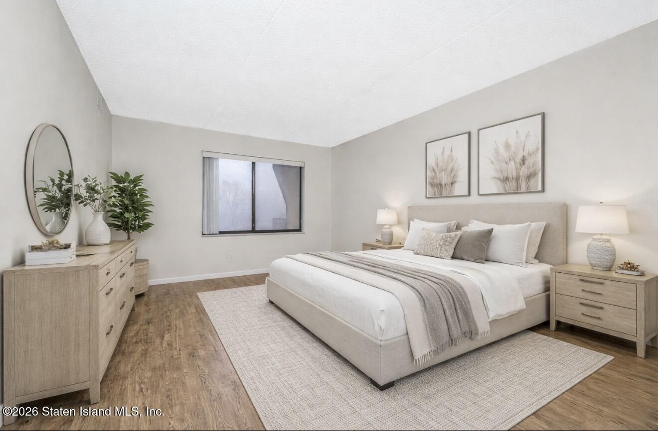 5 Windham Loop, Unit 6E Staten Island, NY 10314 - Photo 20 of 25 a bedroom with a large bed and a chandelier