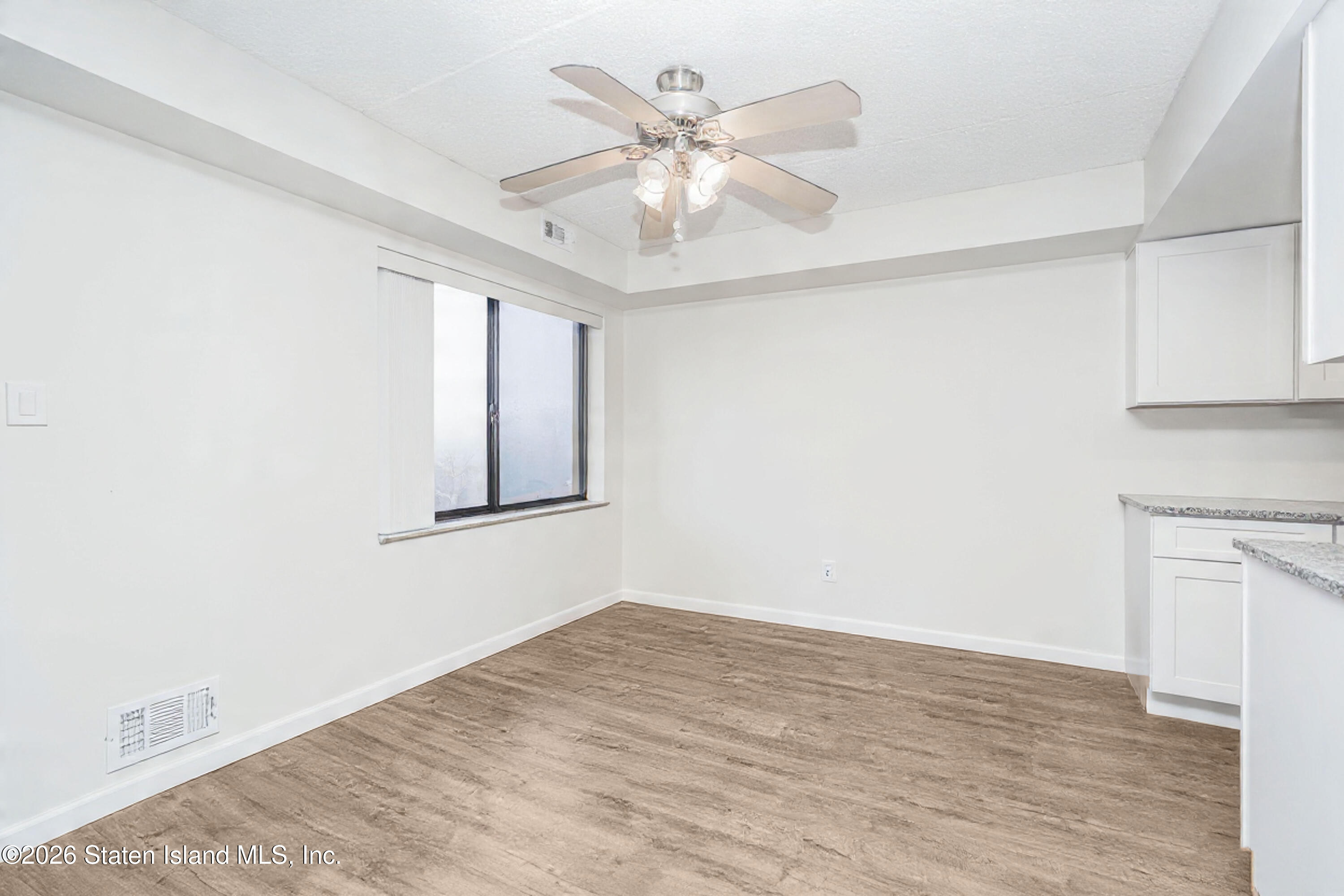 5 Windham Loop, Unit 6E Staten Island, NY 10314 - Photo 9 of 25 wooden floor in an empty room with a window