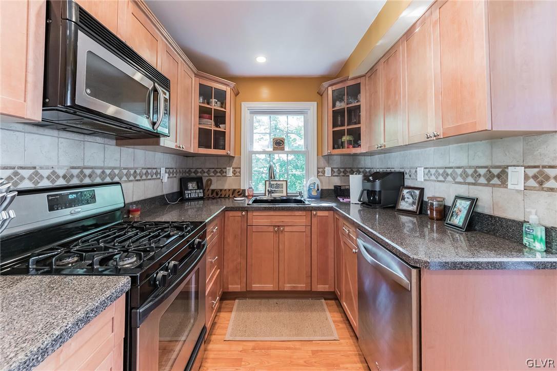 1131 County Line Road Hatboro, PA 19040 - Photo 3 of 18 a kitchen with stainless steel appliances granite countertop a stove sink microwave and cabinets