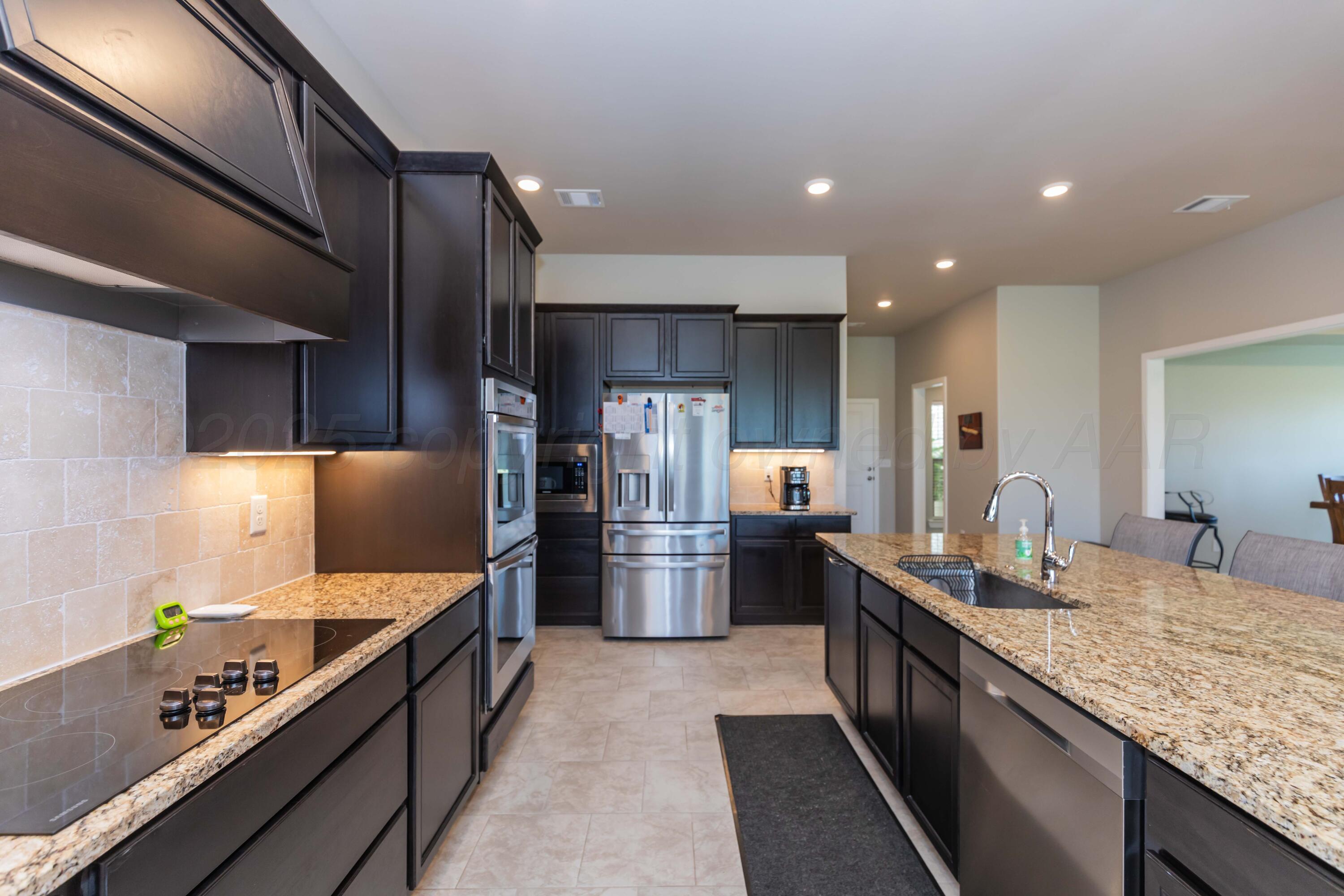 2600 Daybreak Lane Amarillo, TX 79124 - Photo 11 of 52 a kitchen with stainless steel appliances kitchen island granite countertop a sink stove and refrigerator